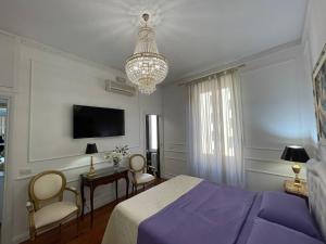 ローマにあるKing Plazaのベッドルーム(紫色のベッド1台、シャンデリア付)