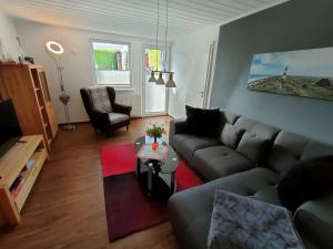 sala de estar con sofá y mesa en Ferienhaus "Sommerbrise", en Gager