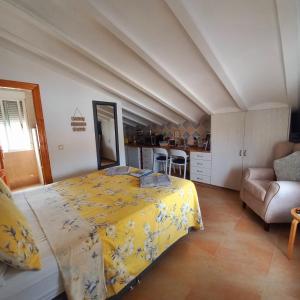 a bedroom with a yellow bed and a kitchen at The Loft Cantoria - Room With a View in Cantoria