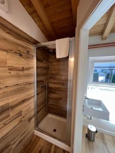 La salle de bains est pourvue d'une douche et de murs en bois. dans l'établissement Borgovivo Il tuo Loft in centro città, à Bergame