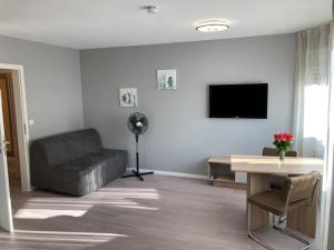 sala de estar con sofá y TV en Ferienwohnung Winkler, en Augsburg