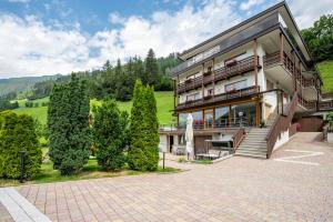 a large building with trees in front of it at Zimmerhofer C Dolomiti in Cadipietra