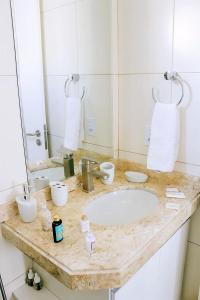 納塔爾的住宿－Apple Flat Natal，浴室的柜台设有水槽和镜子