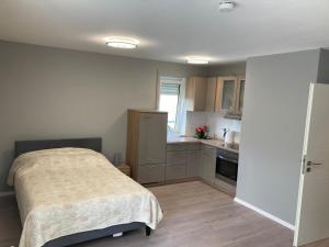 1 dormitorio pequeño con 1 cama y cocina en Ferienwohnung Winkler en Augsburg