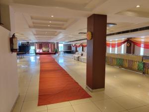 a lobby with a long red carpet in a building at Kartikay hotel in Hisār