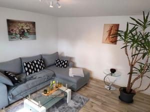 uma sala de estar com um sofá cinzento e um vaso de plantas em Sellina em Ostseebad Sellin