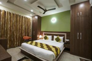 a bedroom with a large bed and a green wall at Kartikay hotel in Hisār