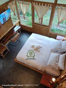Cette chambre comprend un grand lit et un piano. dans l'établissement สวนเกษตรรักษ์ไผ่ Bamboo Conservation Farm, à Surin