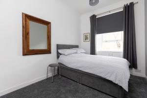 um quarto com uma cama com um espelho e uma janela em Lovely City Centre 1 bedroom flat. em Perth