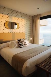 um quarto com uma cama grande e uma janela em Anamcara Suites em Las Indias