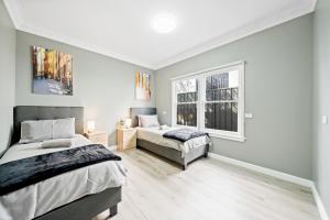 a bedroom with two beds and a window at New 2 Bedroom House 500m to Mall with Free Parking in Bankstown