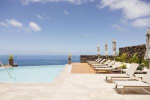 uma piscina com cadeiras e vista para o oceano em Anamcara Suites em Las Indias
