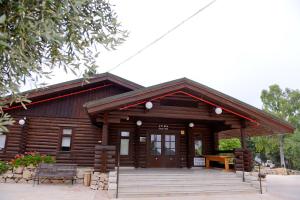 a log cabin with a porch and a bench at Logos hotel in Yad Hashmona in Yad Hashmona