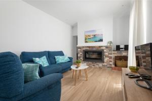 ein Wohnzimmer mit einem blauen Sofa und einem Kamin in der Unterkunft Ca na Menuda in Sencelles