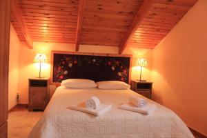 a bedroom with a large bed with two towels on it at Patriko in Arachova