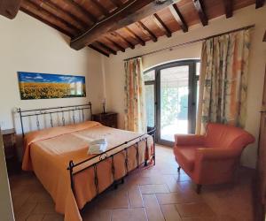 a bedroom with a bed and a chair and a window at Agriturismo Santa Cristina in Gambassi Terme +80 photos