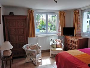 1 dormitorio con cama, silla y vestidor en T1 ou T2 dans villa avec jardin proche Biarritz, en Anglet