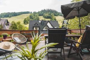 a patio with a table and chairs and an umbrella at Harendzianka in Zakopane
