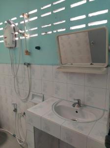 a bathroom with a sink and a shower with a mirror at Charung Bungalows in Haad Rin