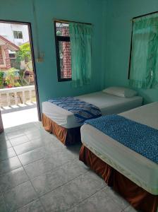 two beds in a room with blue walls at Charung Bungalows in Haad Rin
