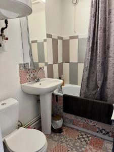 a bathroom with a sink and a toilet and a tub at Sénane - Joli studio à 50m de la plage, parking in Courseulles-sur-Mer