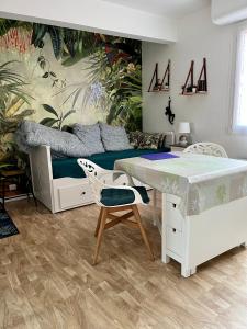 a bedroom with a bed and a desk and a table at Sénane - Joli studio à 50m de la plage, parking in Courseulles-sur-Mer