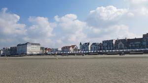 widok na plażę z budynkami w tle w obiekcie La rose des vents w mieście Wimereux