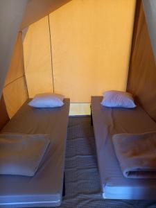 two beds in a small room with yellow walls at CAMPING ONLYCAMP CHAMARGES in Die