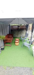 a patio with a bench and chairs under a canopy at La maison Bras des Songes in Saint-André