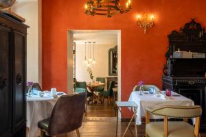 a restaurant with two tables and a dining room with orange walls at Casa L'Andrunèl in Limone sul Garda