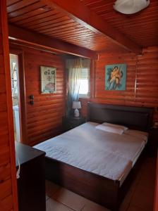 ein Schlafzimmer mit einem Bett in einem Holzzimmer in der Unterkunft ΤΟ ΡΕΤΙΡΕ in Athen