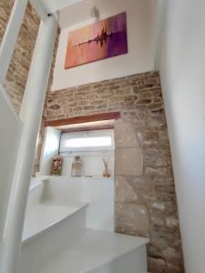 escalera en una habitación con pared de piedra en La Nacre de Saint Aubin sur Mer, en Saint-Aubin-sur-Mer