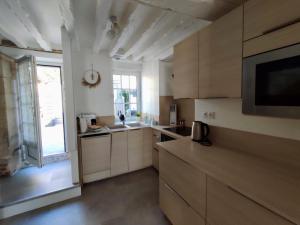 a kitchen with white cabinets and a large window at La Nacre de Saint Aubin sur Mer in Saint-Aubin-sur-Mer +15 photos