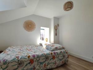 1 dormitorio con 1 cama con edredón de flores en La Nacre de Saint Aubin sur Mer, en Saint-Aubin-sur-Mer