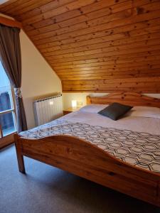 Cama en habitación con techo de madera en Guesthouse Jelenov greben en Podčetrtek