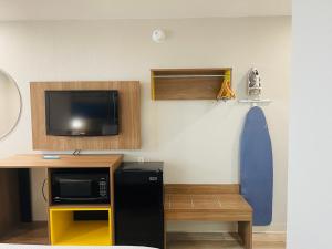 Zimmer mit einem TV und einem Schreibtisch mit einer Mikrowelle. in der Unterkunft Days Inn by Wyndham Killeen Fort Hood in Killeen