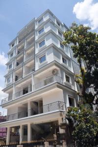 a tall white building with a balcony at PRINCE PALACE in Jhārgrām