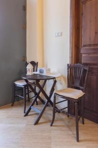 mesa, 2 sillas y mesa y sillas de madera. en Ktima Viro, en Filiatra