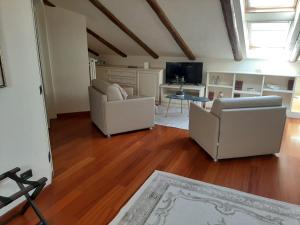 ein Wohnzimmer mit 2 Stühlen und einem TV in der Unterkunft Relais Juliette in La Morra
