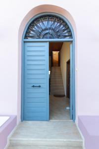 una puerta azul que da a un pasillo con una escalera en Ktima Viro, en Filiatra