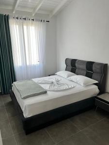 1 dormitorio con 1 cama con cabecero negro en Solen Apartments en Durrës