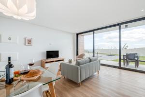 a living room with a couch and a table with wine glasses at Vila Inanda in Ponta do Sol