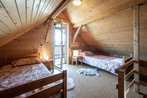 a bedroom with two beds in a wooden cabin at ZIDANICA KRŠTINC in Straža