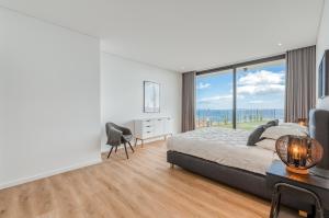 a bedroom with a bed and a large window at Vila Inanda in Ponta do Sol