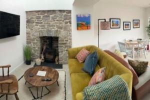 a living room with a couch and a fireplace at River Cottage in Abercraf