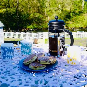 a table with cookies and a tea pot on it at River Cottage in Abercraf