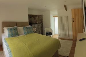 a bedroom with a bed with a green blanket at River Cottage in Abercraf