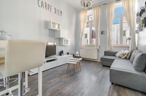 a white living room with a couch and a tv at Appartement 20 min du Circuit Spa-Francorchamps, in Verviers