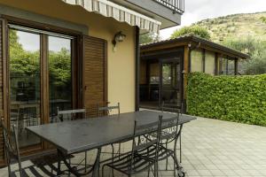 - une table et des chaises sur la terrasse d'une maison dans l'établissement Villa Sara sull'etna con Piscina, à Viagrande