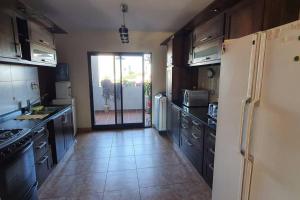 eine Küche mit einem Kühlschrank und eine Tür zum Hof in der Unterkunft Excelente Depto para 4 pers en zona estratégica in Santiago del Estero